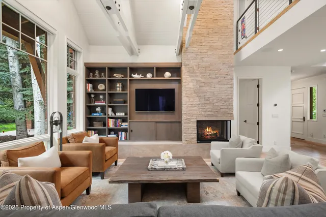 a living room with furniture fireplace and a large window
