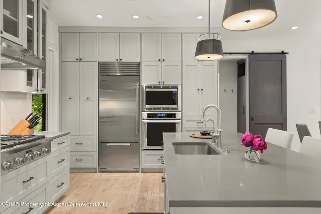 a kitchen with stainless steel appliances kitchen island granite countertop a refrigerator and a stove
