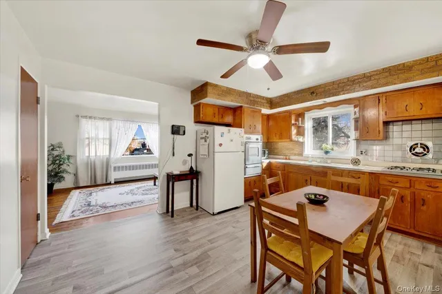 a view of a livingroom with furniture a ceiling fan and wooden floor