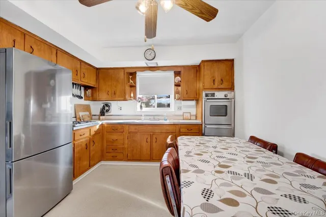 a kitchen with stainless steel appliances granite countertop a refrigerator a sink dishwasher a stove with white cabinets and wooden floor