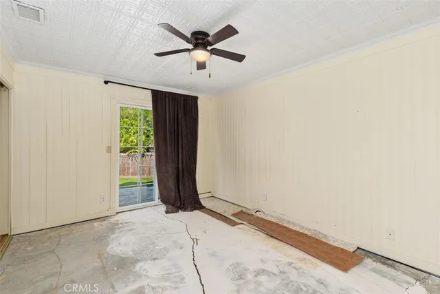 an empty room with windows and ceiling fan