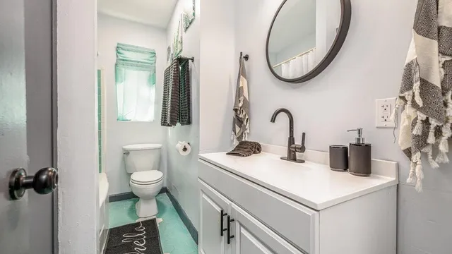 a bathroom with a toilet sink and mirror