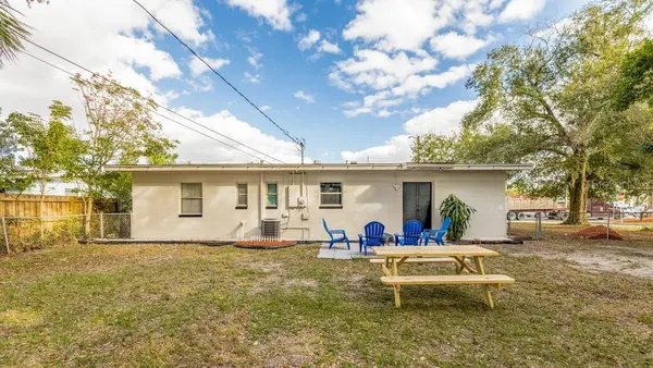 a view of a house with backyard and sitting area
