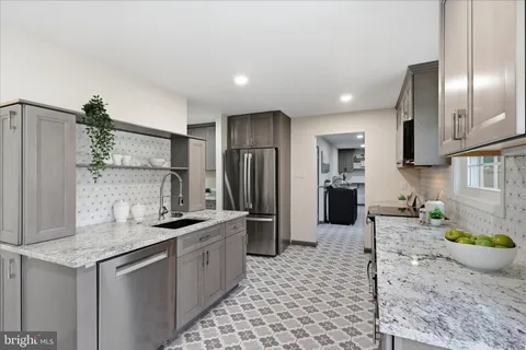 a kitchen with stainless steel appliances granite countertop a sink refrigerator and cabinets