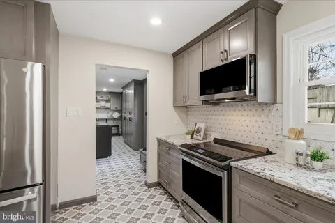 a kitchen with stainless steel appliances kitchen island granite countertop a refrigerator and a stove top oven