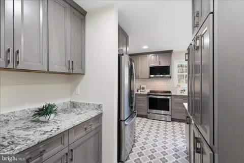 a kitchen with granite countertop a stove and a refrigerator