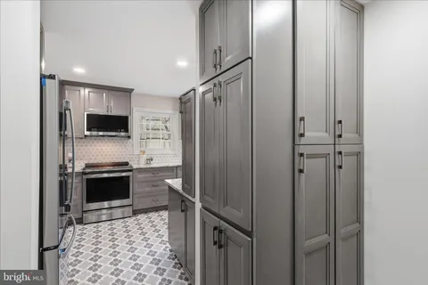 a kitchen with stainless steel appliances granite countertop a refrigerator and a stove top oven