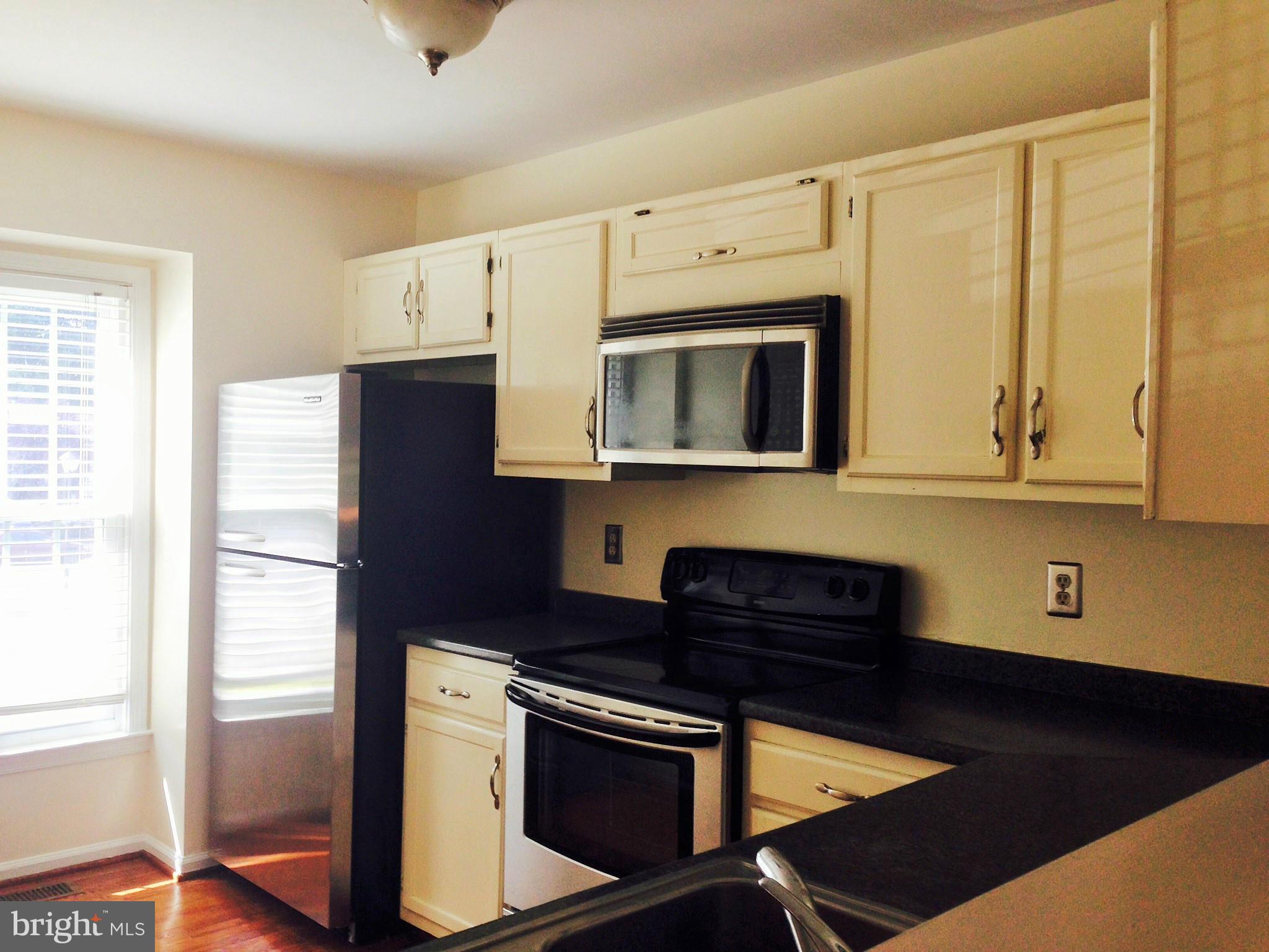 7933 Pebble Brook Court Springfield, VA 22153 - Photo 2 of 18 a kitchen with stainless steel appliances granite countertop a stove a microwave and a refrigerator