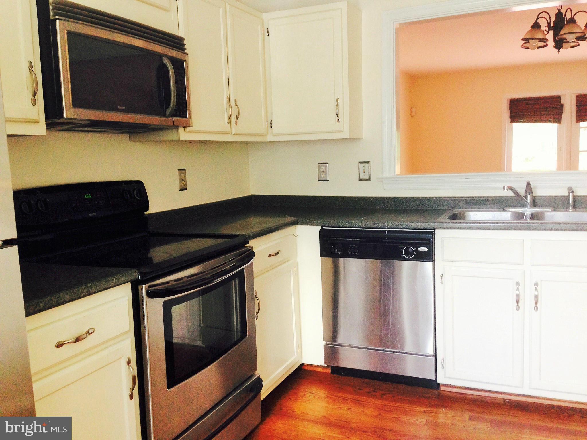 7933 Pebble Brook Court Springfield, VA 22153 - Photo 4 of 18 a kitchen with granite countertop a stove and a microwave