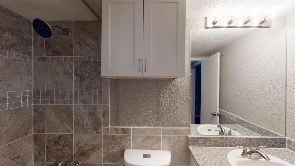 1407 15th Place, Unit A1AHR Plano, TX 75074 - Photo 14 of 14 Full bath with tiled shower, vanity, and a textured wall