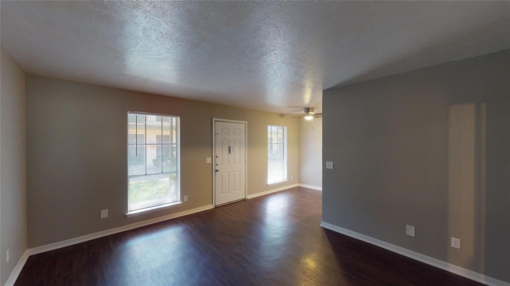1407 15th Place, Unit A1AHR Plano, TX 75074 - Photo 4 of 14 Entrance foyer with dark wood-style floors, a textured ceiling, and a ceiling fan