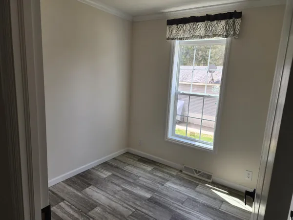 a view of empty room with wooden floor