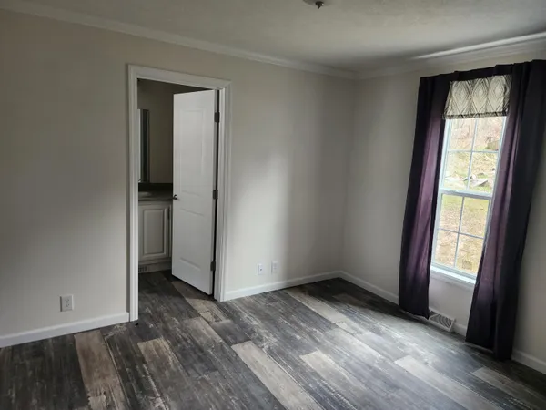 an empty room with wooden floor and a window