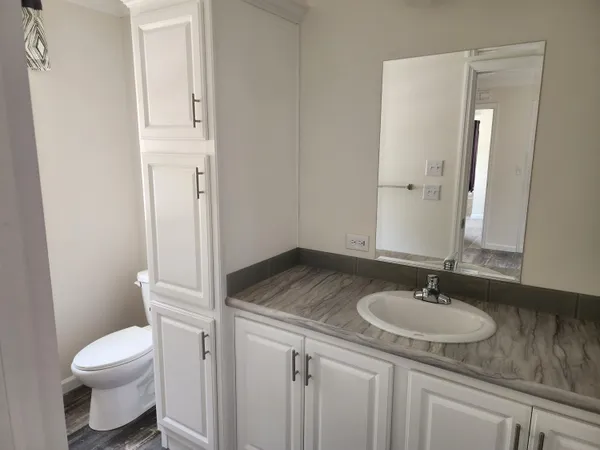 a bathroom with a granite countertop sink toilet and shower