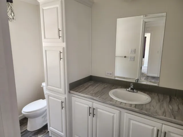 a bathroom with a granite countertop sink toilet and shower