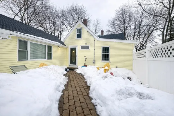 a view of a white house with a yard covered in snow