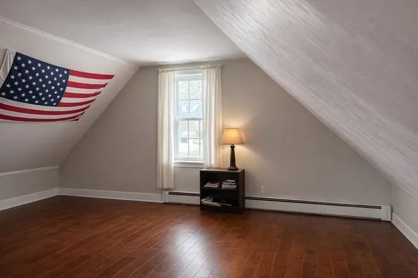 an empty room with wooden floor cabinet and windows