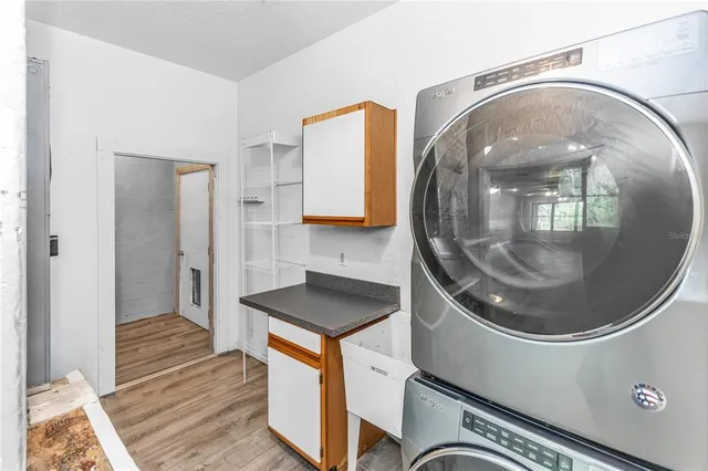 an empty room with wooden floor closet and fan