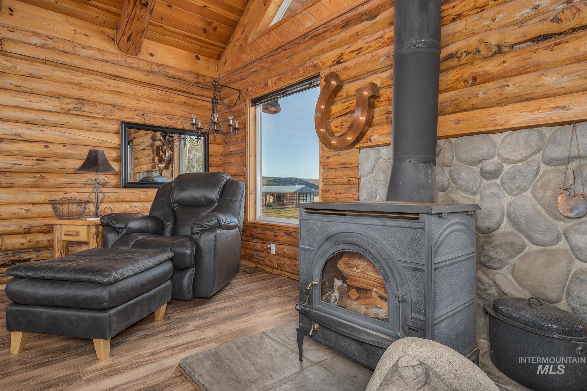1855 Jones Road Weiser, ID 83672 - Photo 7 of 34 Detailed view of a wood stove, wood finished floors, and a wood ceiling with exposed beams