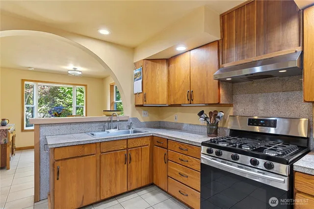 a kitchen with stainless steel appliances a sink stove and cabinets