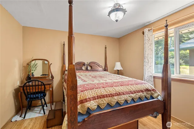 a bedroom with a bed a chandelier and a window