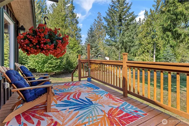 a balcony with couple of chairs and a potted plant