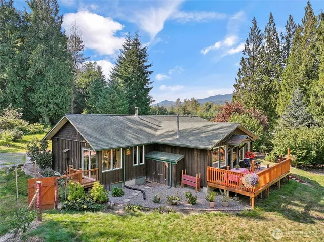 an aerial view of a house with swimming pool and trees around