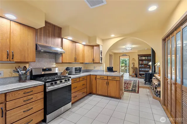 a kitchen with stainless steel appliances granite countertop a stove sink and cabinets