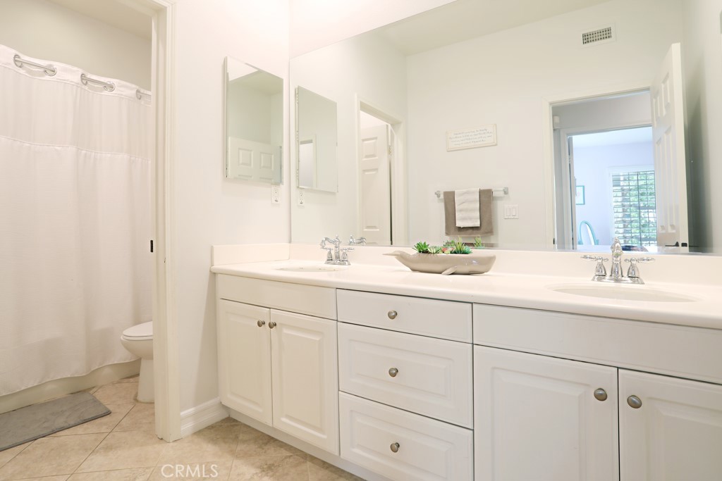 9 Orange Blossom Circle Ladera Ranch, CA 92694 - Photo 15 of 24 a bathroom with double sink a toilet and a mirror