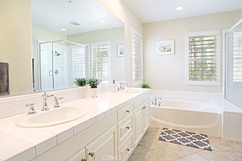 9 Orange Blossom Circle Ladera Ranch, CA 92694 - Photo 16 of 24 a bathroom with a double vanity sink large mirror and a bathtub