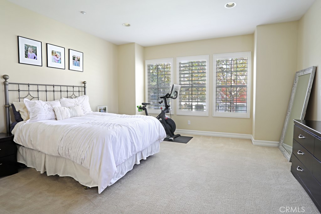 9 Orange Blossom Circle Ladera Ranch, CA 92694 - Photo 18 of 24 a spacious bedroom with a bed a couch and a window