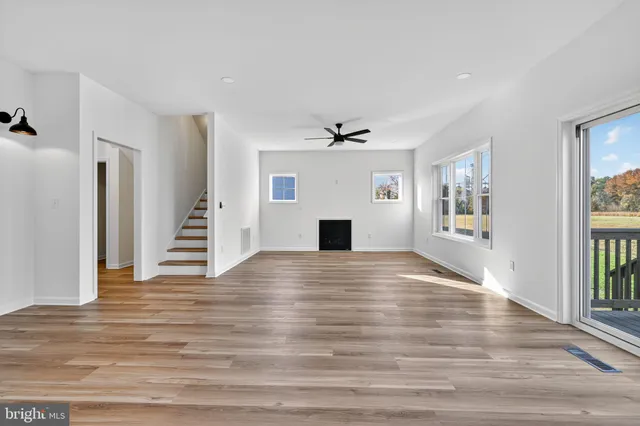 a view of empty room with wooden floor and fireplace