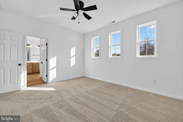 a view of a livingroom with a chandelier fan and windows