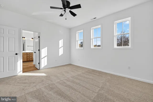 a view of a livingroom with a chandelier fan and windows