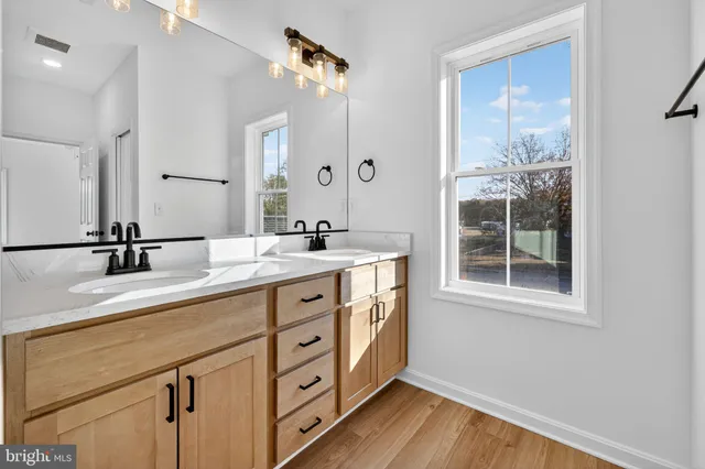 a bathroom with a double vanity sink and mirror with shower
