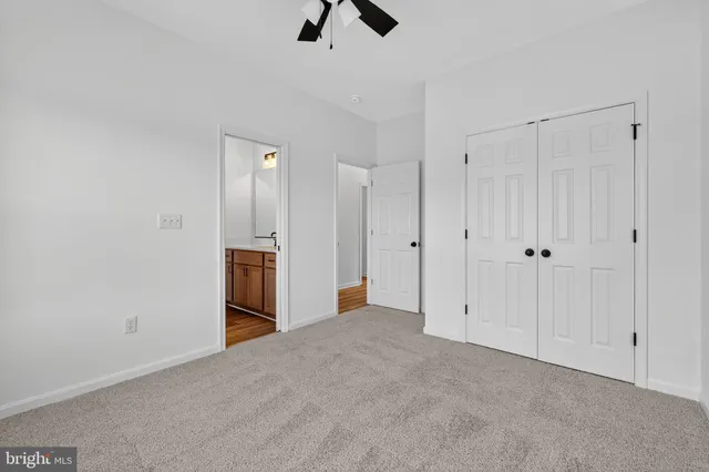 a view of an empty room with chandelier fan and refrigerator