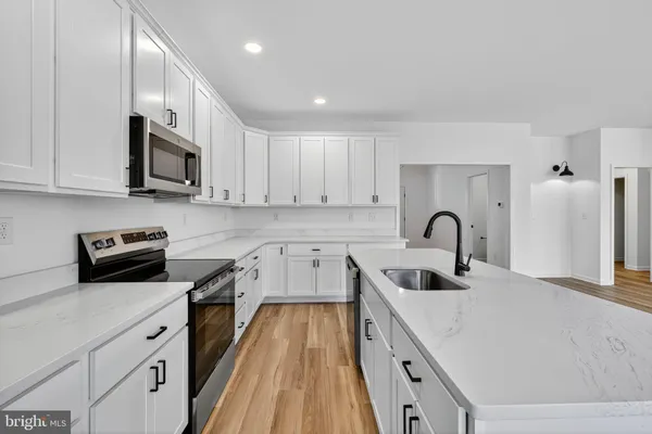a kitchen with granite countertop a sink a stove and cabinets