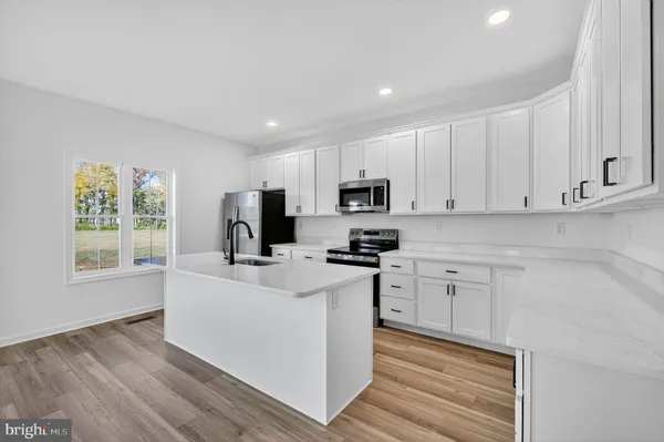 a kitchen with cabinets appliances a sink and a window