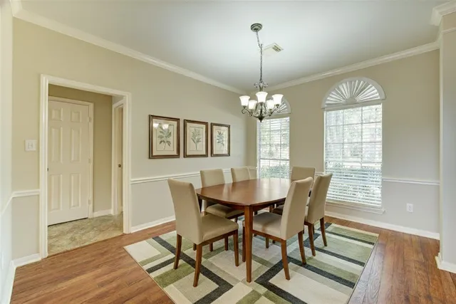 an empty room with wooden floor fireplace and windows