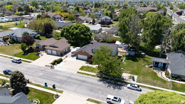 5727 South 3550th Street West Roy, UT 84067 - Photo 42 of 49 Expansive residential property featuring a large front yard, mature trees, and a concrete driveway