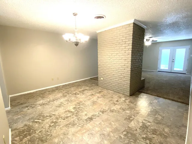 an empty room with a ceiling fan and carpet