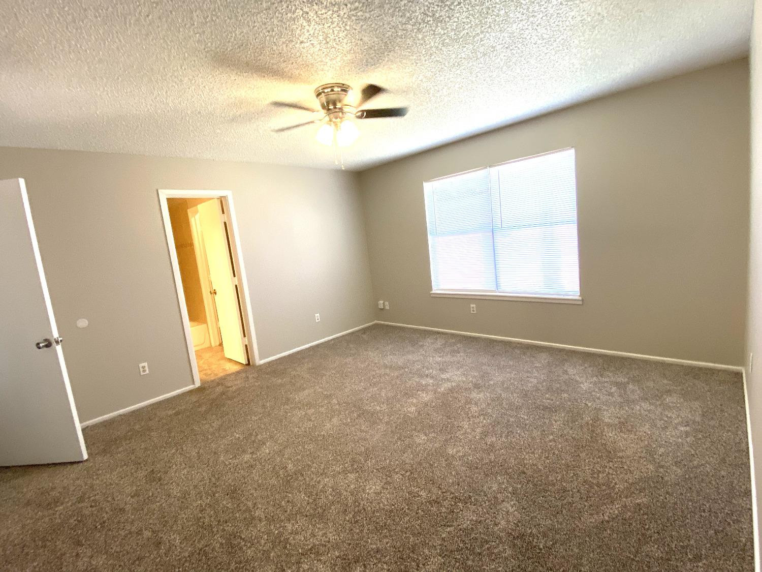9818 Jordan Avenue, Unit A Lubbock, TX 79423 - Photo 18 of 20 an empty room with windows and fan