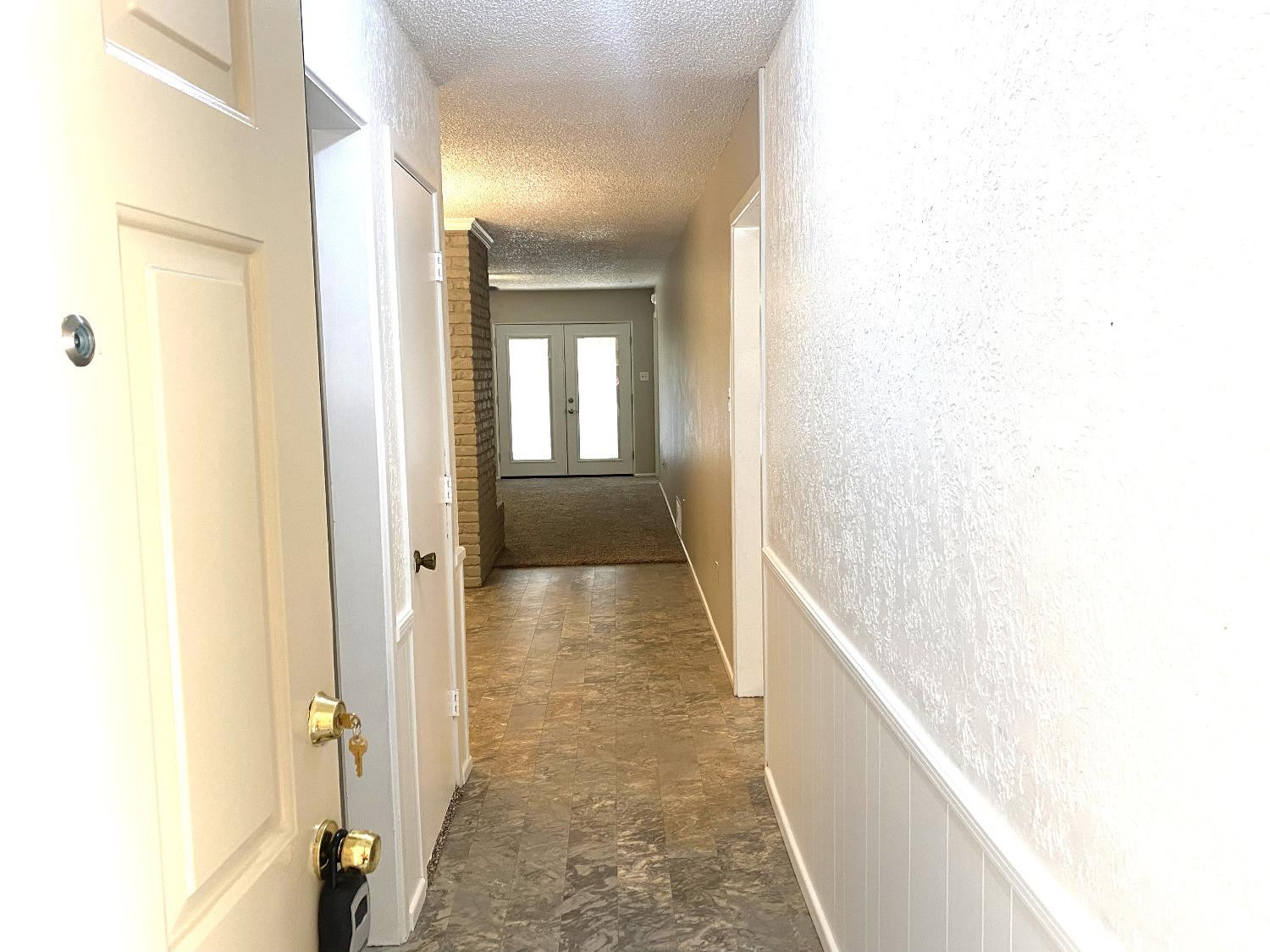 9818 Jordan Avenue, Unit A Lubbock, TX 79423 - Photo 2 of 20 a view of a hallway with wooden floor