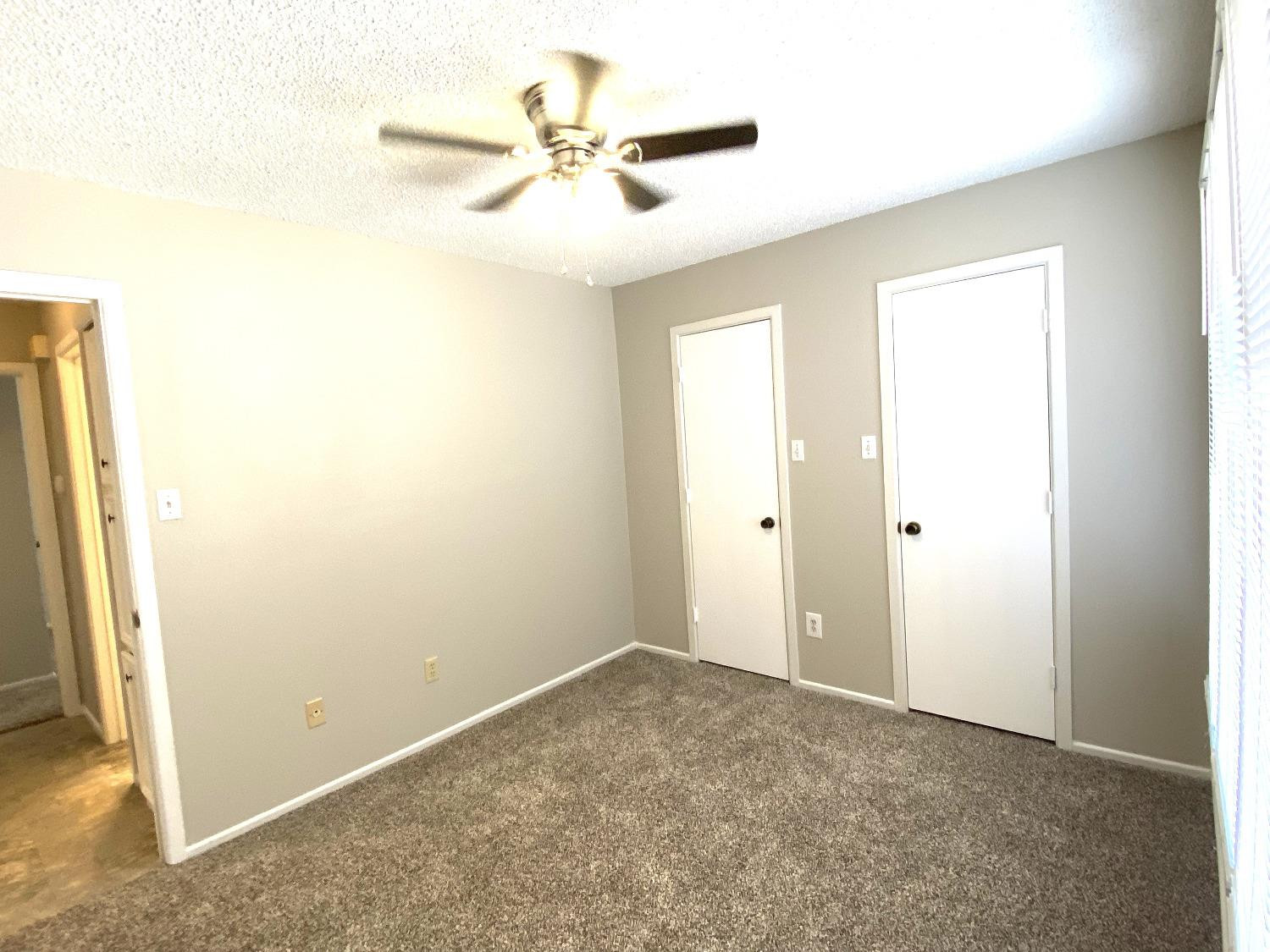 9818 Jordan Avenue, Unit A Lubbock, TX 79423 - Photo 9 of 20 an empty room with a ceiling fan and a window