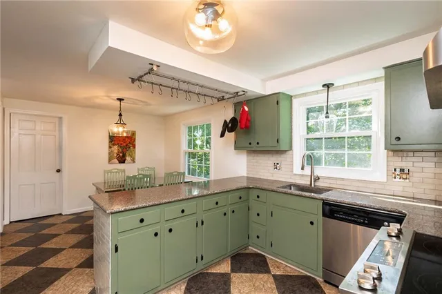 a kitchen with a sink dishwasher a refrigerator with wooden cabinets and floor