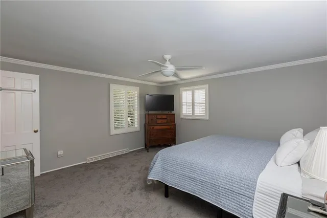 a bedroom with a bed and a flat tv screen on dresser