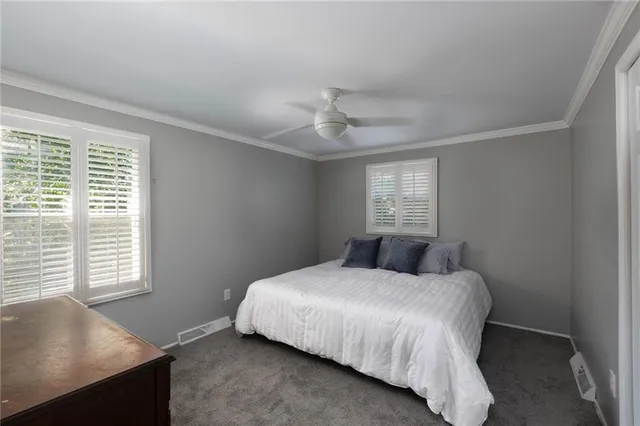 a bedroom with a large bed and windows