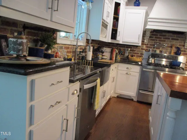 a kitchen with granite countertop a sink stove and cabinets