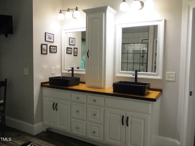 a bathroom with double vanity and a mirror