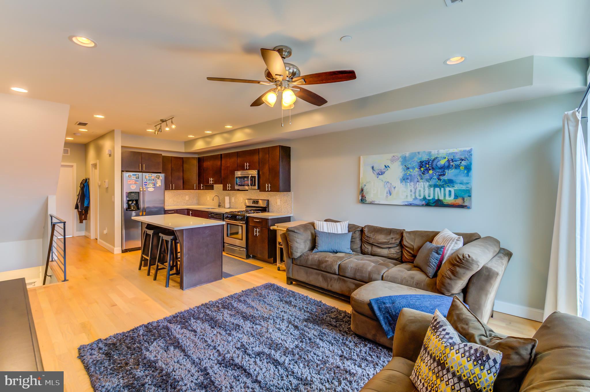 a living room with furniture a ceiling fan and a rug